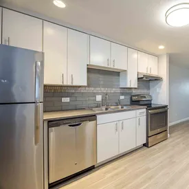 Galley kitchen with white cabinets at Lime Apartments